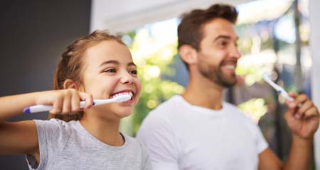 Family Dentistry - Father Daughter Brushing Their Teeth