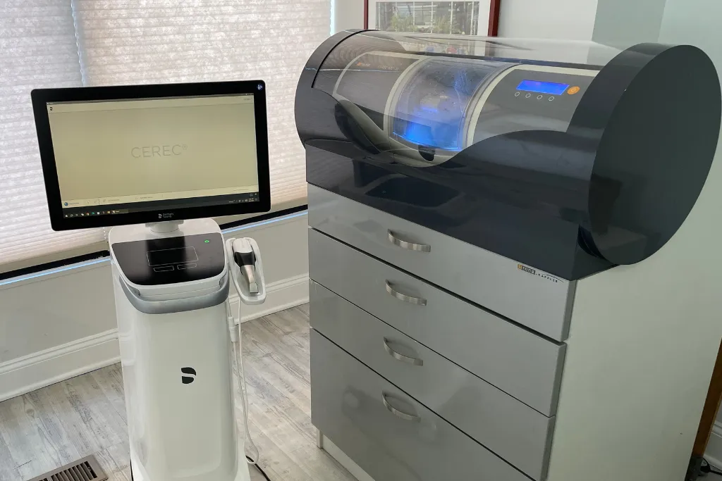 Modern Philadelphia dental clinic featuring advanced technology, including a digital intraoral scanner displaying a 3D tooth model, ergonomic dental chair, live X-ray monitor, 3D-printed tools, and ceramic crowns in a bright, meticulously maintained treatment room.